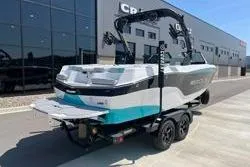 Slide: The Image of 2025 MasterCraft XT22 boat on trailer, parked outside modern building. - 6