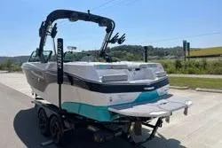 Slide: The Image of 2025 MasterCraft XT22 boat on trailer, parked outdoors under clear sky. - 8