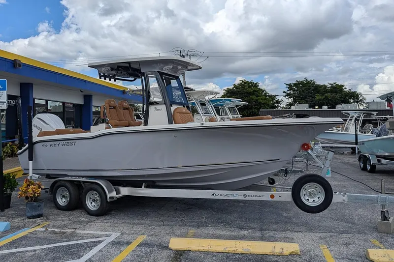 Slide: The Image of 2026 Key West 239 FSR boat on trailer, displayed outdoors under cloudy sky. - 0