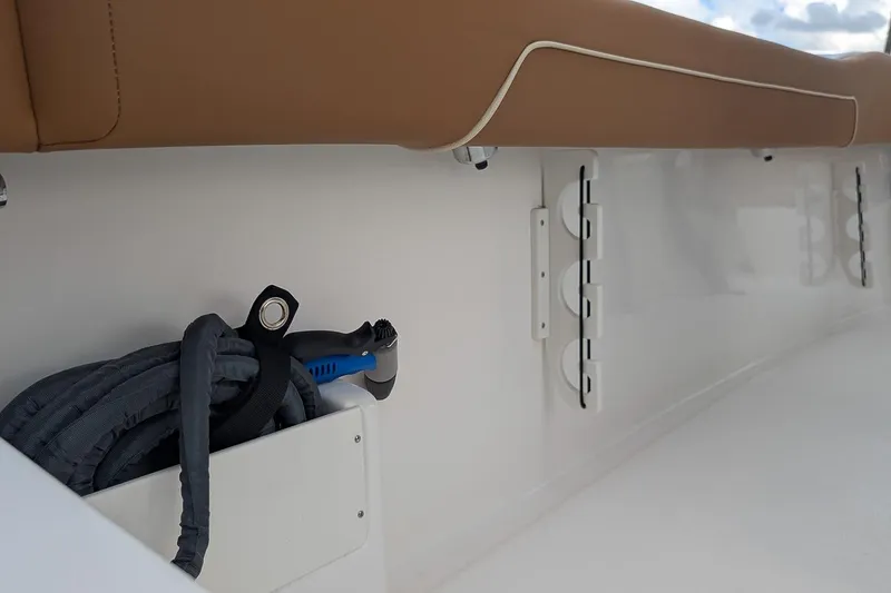 Slide: The Image of 2026 Key West 239 FSR boat interior with storage compartment and hose. - 10