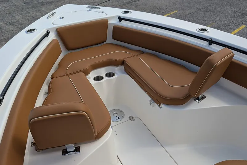 Slide: The Image of 2026 Key West 239 FSR boat interior with brown cushioned seating and cup holders. - 18