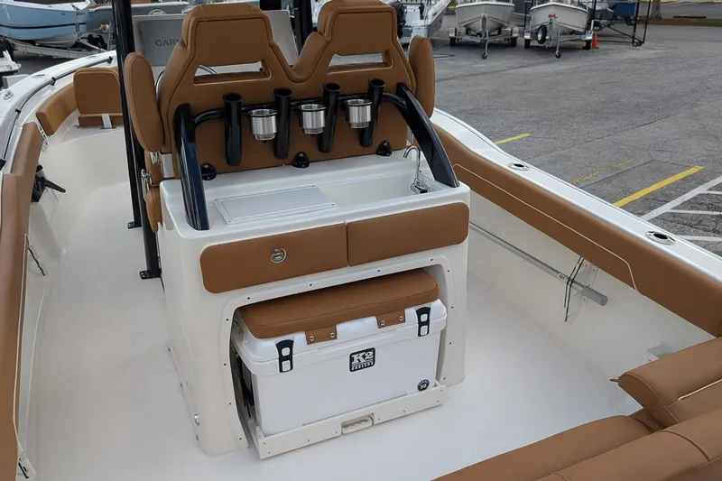 Slide: The Image of 2026 Key West 239 FSR boat interior with tan seating and cooler storage. - 8