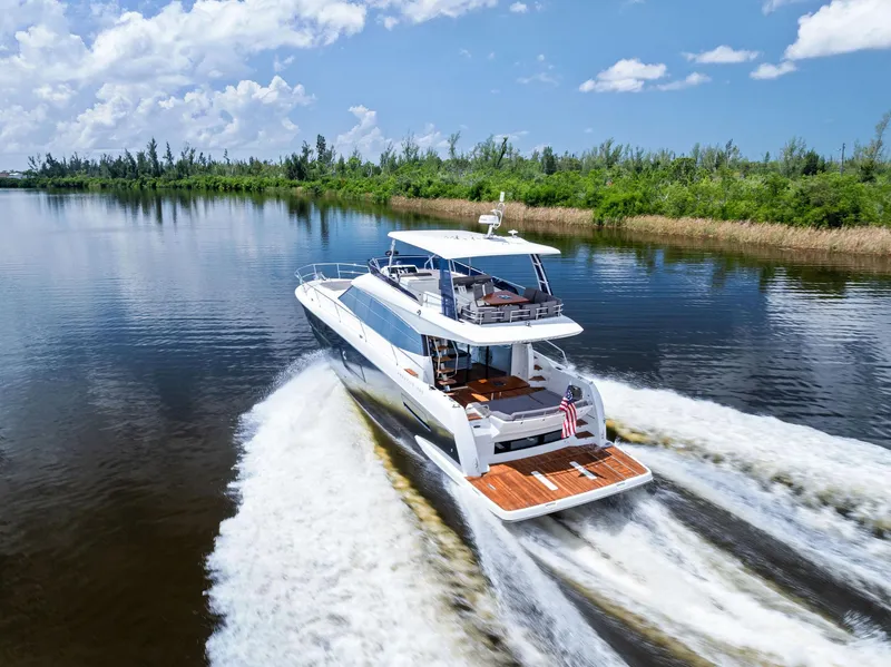 Slide: The Image of Prestige 560 Flybridge yacht cruising on a serene waterway, 2017 model. - 10