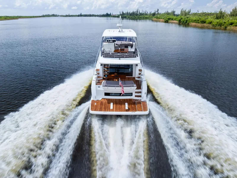 Slide: The Image of Prestige 560 Flybridge yacht cruising on a serene waterway, 2017 model. - 11