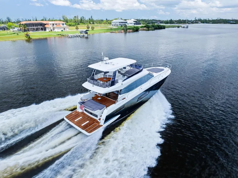 Slide: The Image of 2017 Prestige 560 Flybridge yacht cruising on a scenic waterway. - 12