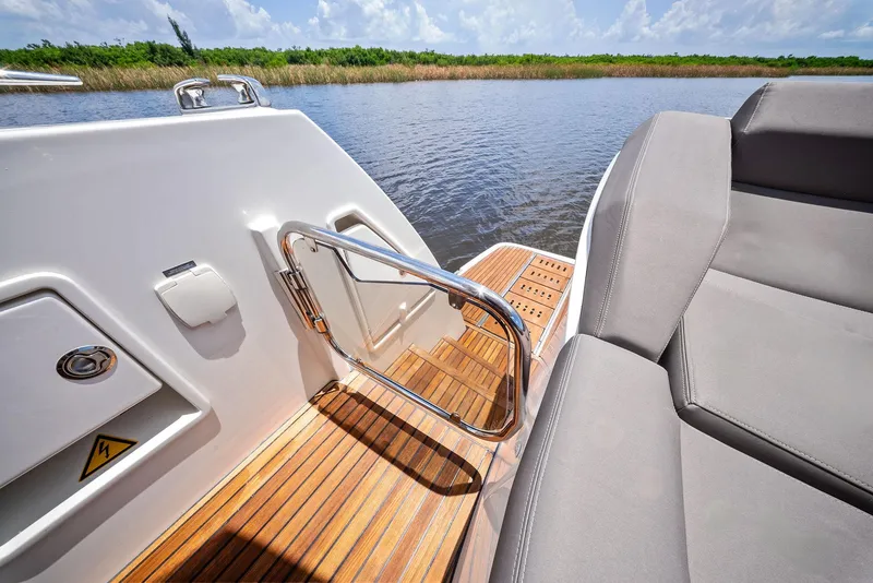 Slide: The Image of Prestige 560 Flybridge 2017 yacht deck with seating, wooden flooring, and water view. - 15