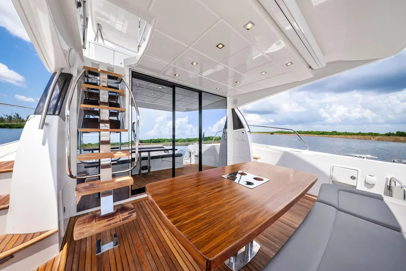 Slide: The Image of Luxurious 2017 Prestige 560 Flybridge yacht interior with wooden table and scenic water view. - 19