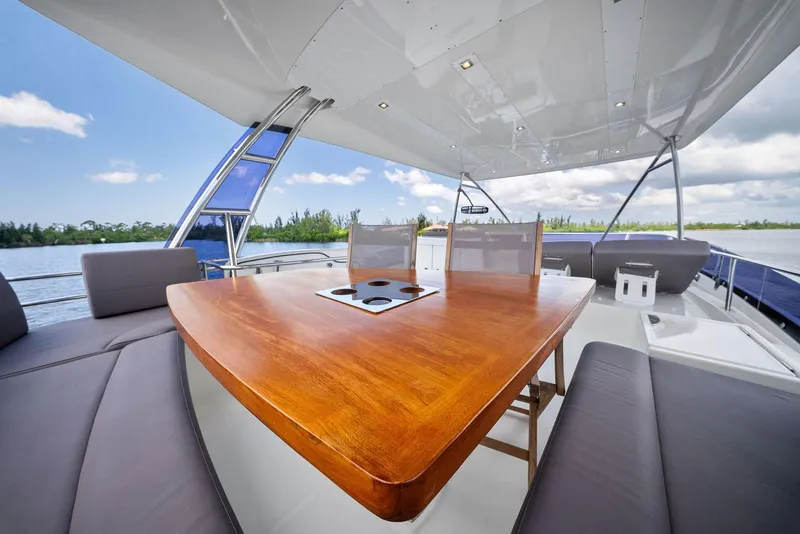 Slide: The Image of Prestige 560 Flybridge 2017 yacht with elegant outdoor seating and wooden table. - 29