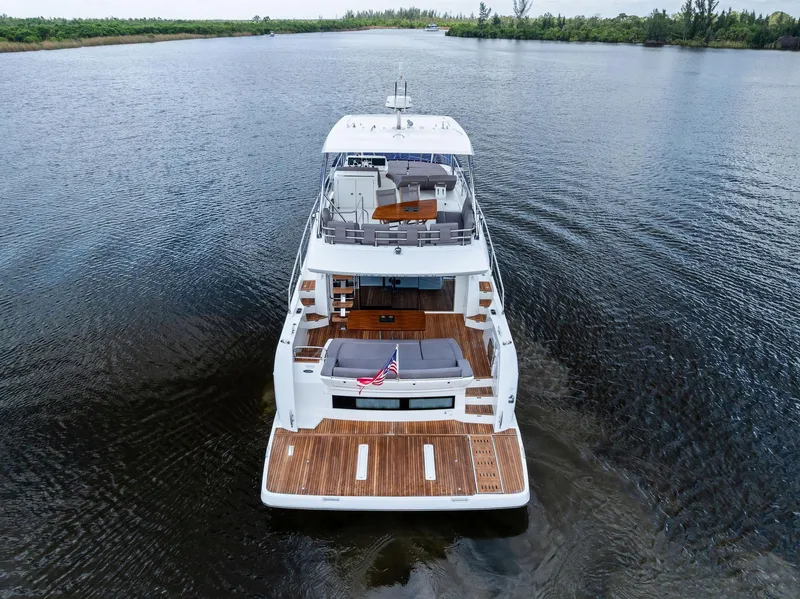 Slide: The Image of 2017 Prestige 560 Flybridge yacht on calm water, rear view. - 3