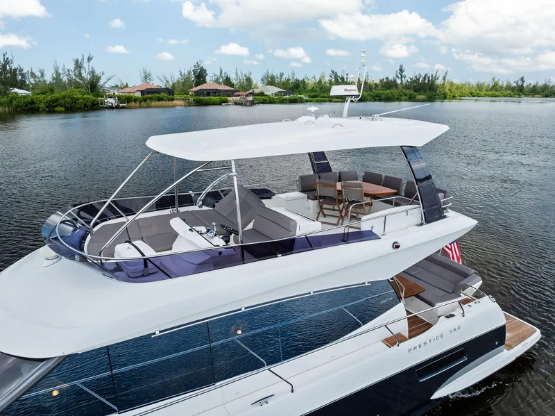 Slide: The Image of Prestige 560 Flybridge yacht, 2017 model, cruising on a serene lake under a blue sky. - 30