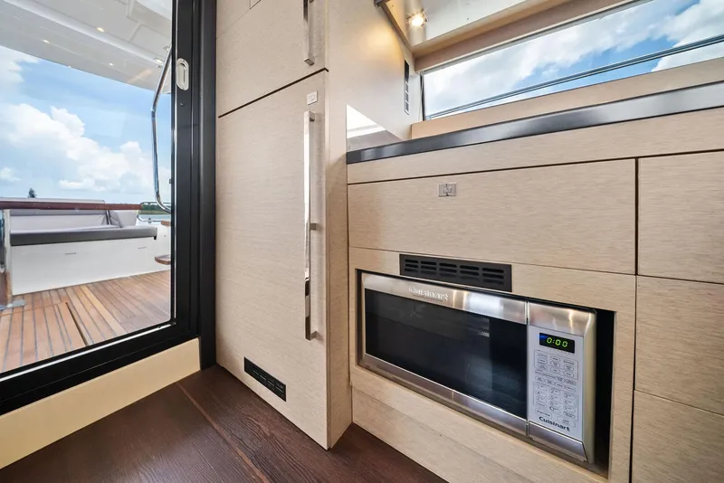 Slide: The Image of Modern kitchen interior on 2017 Prestige 560 Flybridge yacht, featuring sleek cabinetry and microwave. - 36