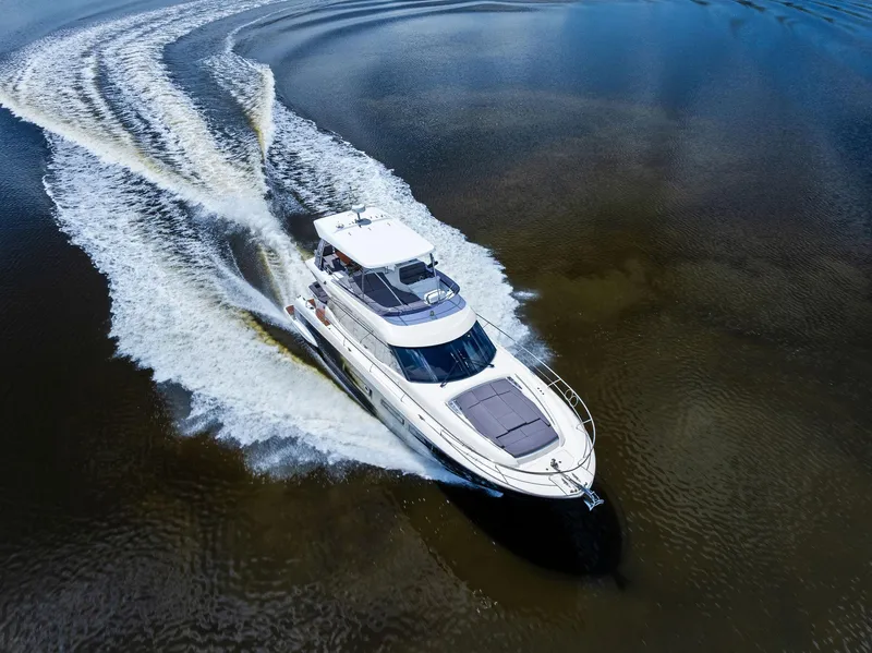 Slide: The Image of 2017 Prestige 560 Flybridge yacht cruising on open water, aerial view. - 6