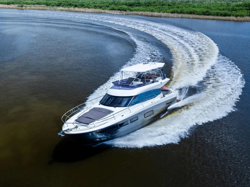 Slide: The Image of 2017 Prestige 560 Flybridge yacht making a sharp turn on a calm river. - 7