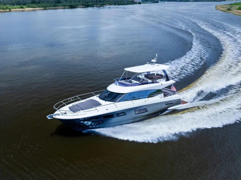 Slide: The Image of 2017 Prestige 560 Flybridge yacht cruising on a calm river. - 8