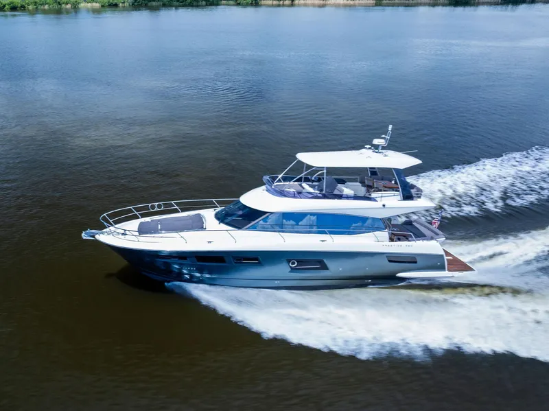 Slide: The Image of 2017 Prestige 560 Flybridge yacht cruising on a calm river. - 9