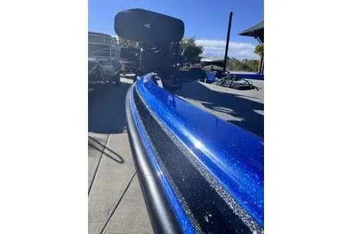 Slide: The Image of 2022 Phoenix 921 ELITE boat with a sleek blue finish, parked outdoors. - 2