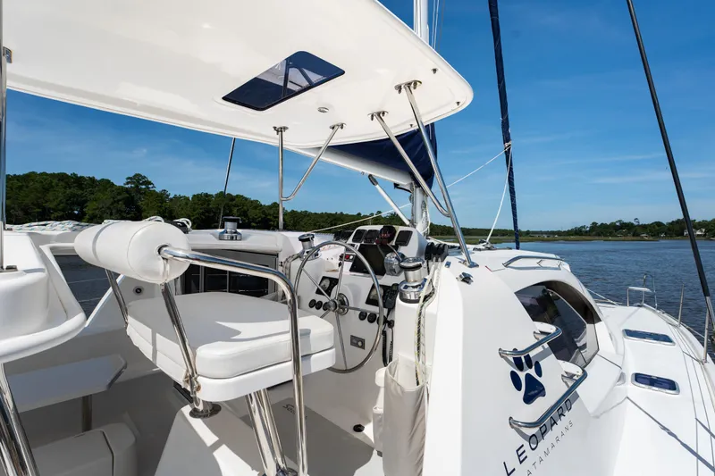 Slide: The Image of 2016 Leopard 44 Owners Version catamaran with blue canopy and clear windows at marina. - 11