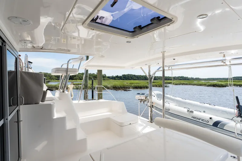 Slide: The Image of 2016 Leopard 44 Owners Version catamaran with American flag, docked in serene waters. - 22