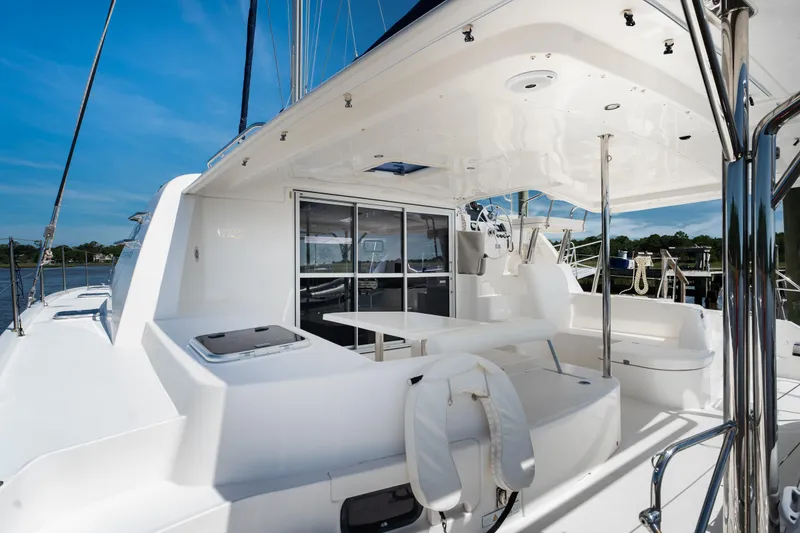 Slide: The Image of 2016 Leopard 44 Owners Version yacht with American flag, docked on a serene river. - 23