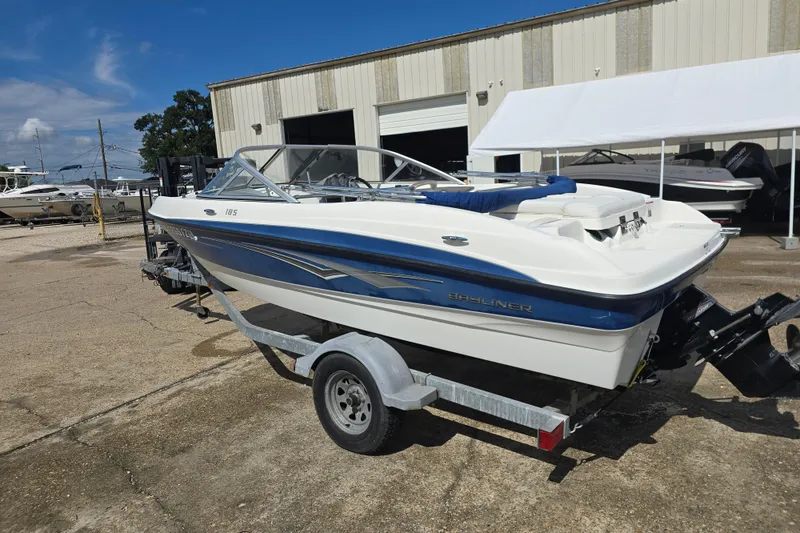 Slide: The Image of 2010 Bayliner 185 Bowrider boat on trailer, parked outside a warehouse. - 5