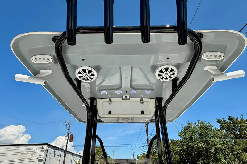 Slide: The Image of 2015 Sea Hunt RZR 24 boat T-top with speakers and rod holders against blue sky. - 12