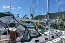 Slide: The Image of Sailboat Caliber 40LRC 1999 docked, featuring green canopy and clear skies. - 10