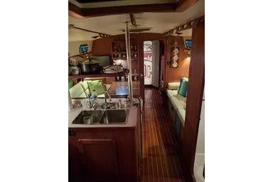 Slide: The Image of 1999 Caliber 40LRC yacht interior with kitchen, seating, and wooden flooring. - 13