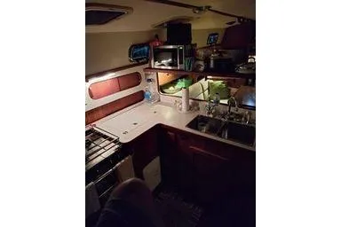 Slide: The Image of 1999 Caliber 40LRC yacht interior kitchen with stove, sink, and storage. - 14
