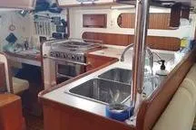 Slide: The Image of 1999 Caliber 40LRC yacht interior kitchen with stove, sink, and wooden cabinetry. - 16