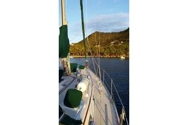 Slide: The Image of Sailboat Caliber 40LRC 1999 on calm water with scenic mountain backdrop. - 37