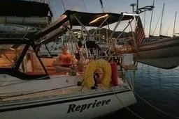 Slide: The Image of Sailboat "Reprieve" docked at sunset, Caliber 40LRC, 1999 model, with American flag. - 9