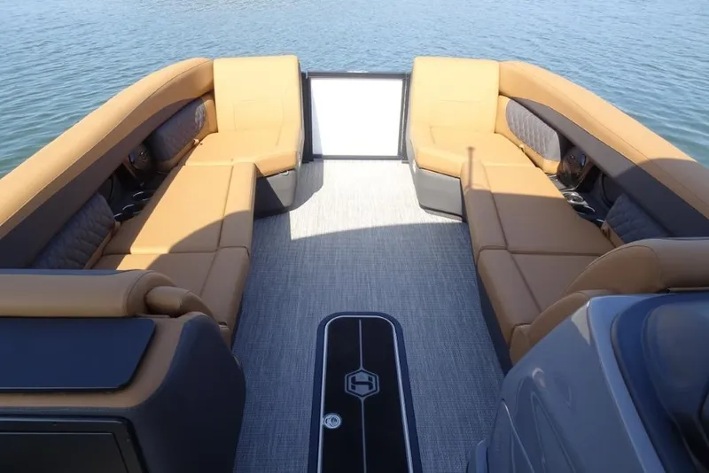 Slide: The Image of 2026 Harris Sunliner 250 boat interior with tan seating and gray flooring on water. - 21