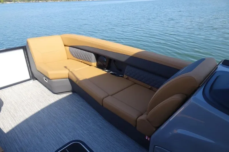 Slide: The Image of 2026 Harris Sunliner 250 boat interior with tan seating, overlooking calm blue water. - 22