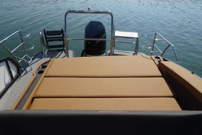 Slide: The Image of 2026 Harris Sunliner 250 boat with tan seating and sleek design on calm water. - 29