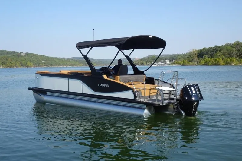 Slide: The Image of 2026 Harris Sunliner 250 pontoon boat on a serene lake with lush green surroundings. - 3
