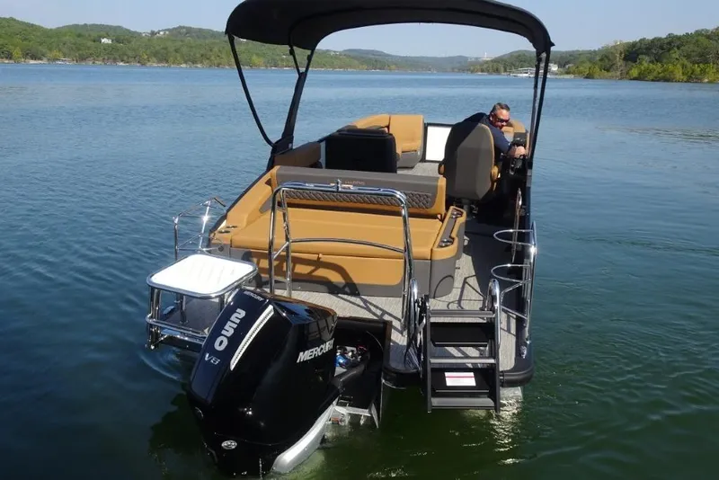 Slide: The Image of 2026 Harris Sunliner 250 pontoon boat on a serene lake with Mercury outboard engine. - 6