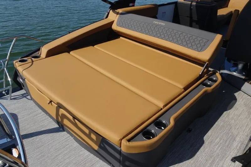 Slide: The Image of Luxurious seating on 2026 Harris Sunliner 250 boat, featuring tan upholstery and cup holders. - 8
