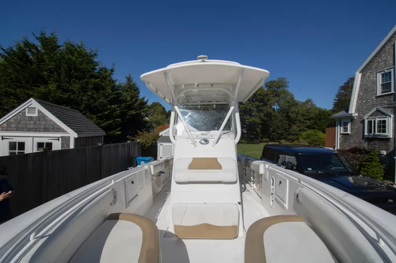 Slide: The Image of 2015 Edgewater 245CC boat in driveway, surrounded by trees and houses. - 6