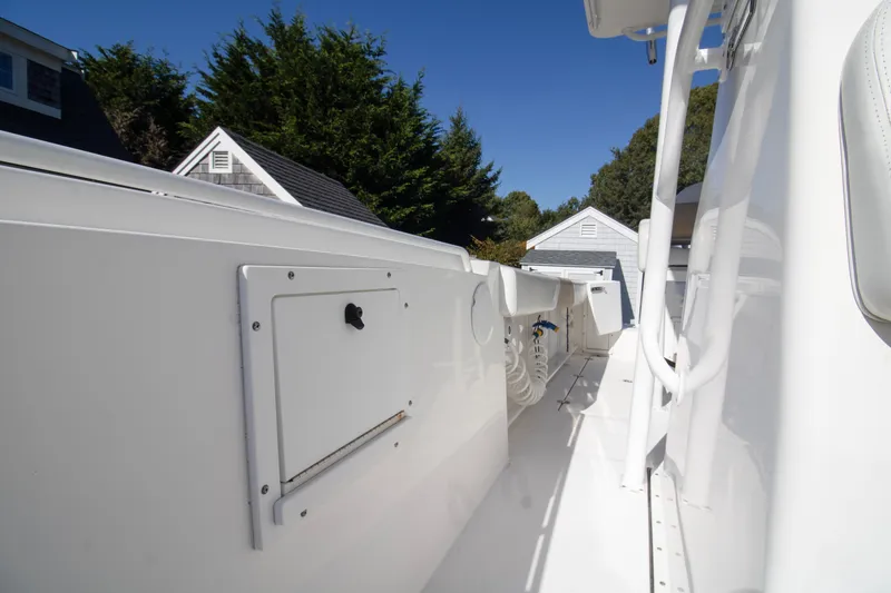 Slide: The Image of 2015 Edgewater 245CC boat interior with storage compartment, white finish, and outdoor setting. - 7