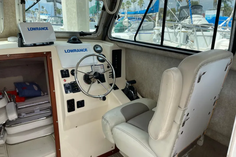 Slide: The Image of Interior of 2002 Parker 2520 XL Sport Cabin with steering wheel and Lowrance equipment. - 13