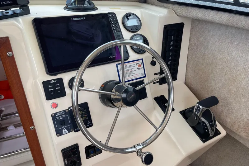 Slide: The Image of 2002 Parker 2520 XL Sport Cabin helm with steering wheel and navigation controls. - 14
