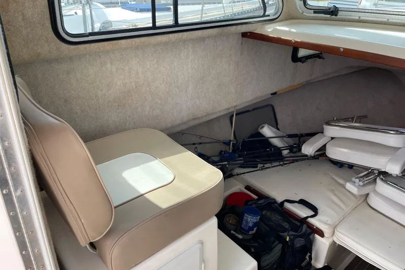 Slide: The Image of Interior of a 2002 Parker 2520 XL Sport Cabin with fishing gear and seating. - 17