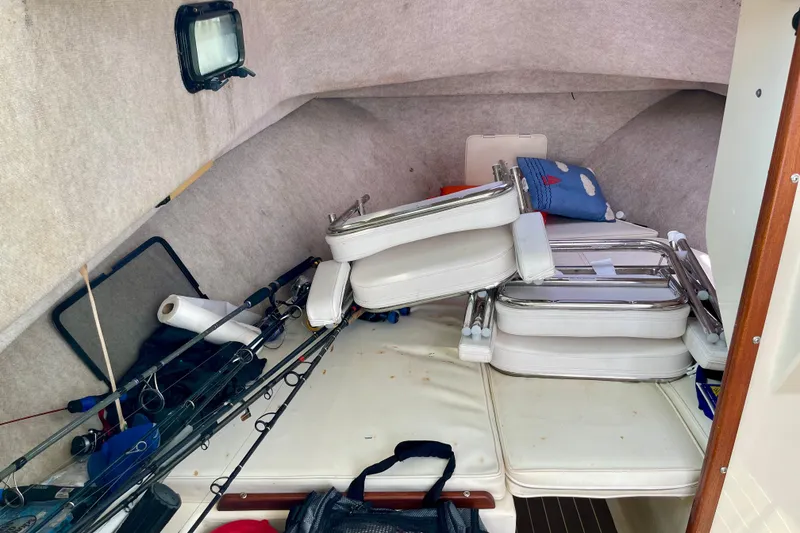Slide: The Image of Interior of 2002 Parker 2520 XL Sport Cabin with fishing gear and folded chairs. - 18