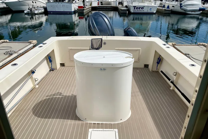 Slide: The Image of 2002 Parker 2520 XL Sport Cabin boat deck with central storage, docked at marina. - 19