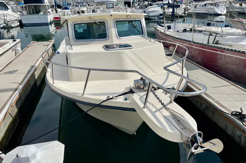 Slide: The Image of 2002 Parker 2520 XL Sport Cabin boat docked in a marina, surrounded by other vessels. - 2