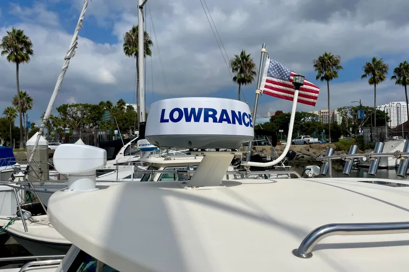 Slide: The Image of 2002 Parker 2520 XL Sport Cabin with Lowrance radar and American flag in marina setting. - 20