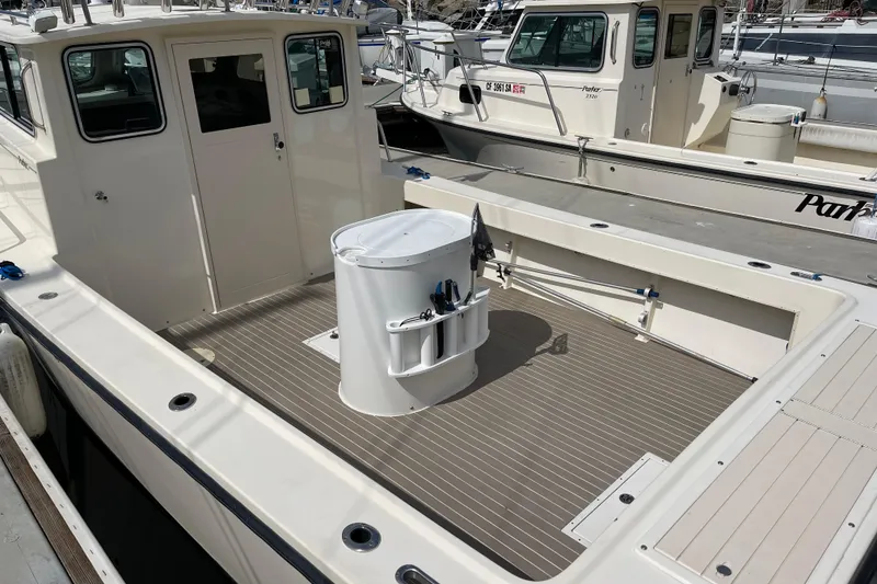 Slide: The Image of 2002 Parker 2520 XL Sport Cabin boat with spacious deck and fishing equipment. - 3