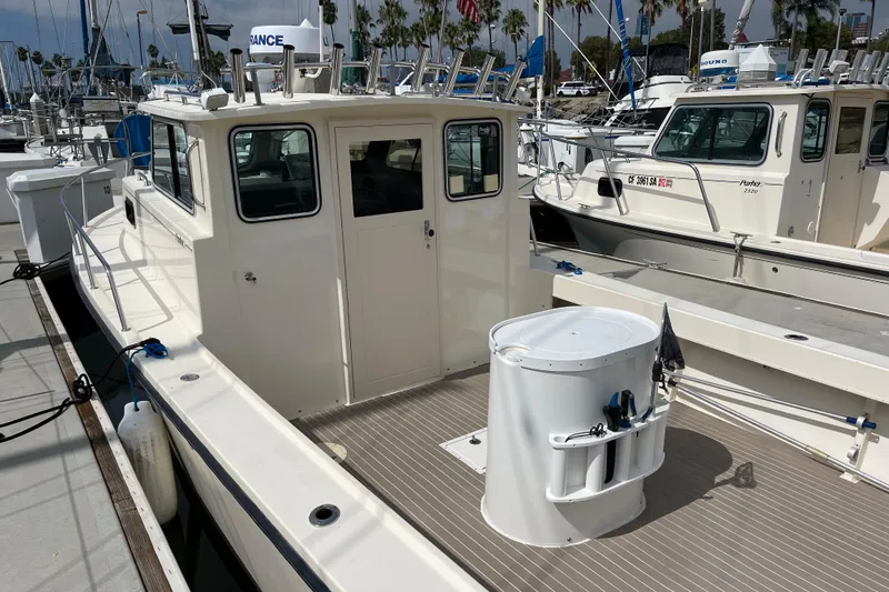 Slide: The Image of 2002 Parker 2520 XL Sport Cabin boat docked at marina, featuring spacious deck and cabin. - 4