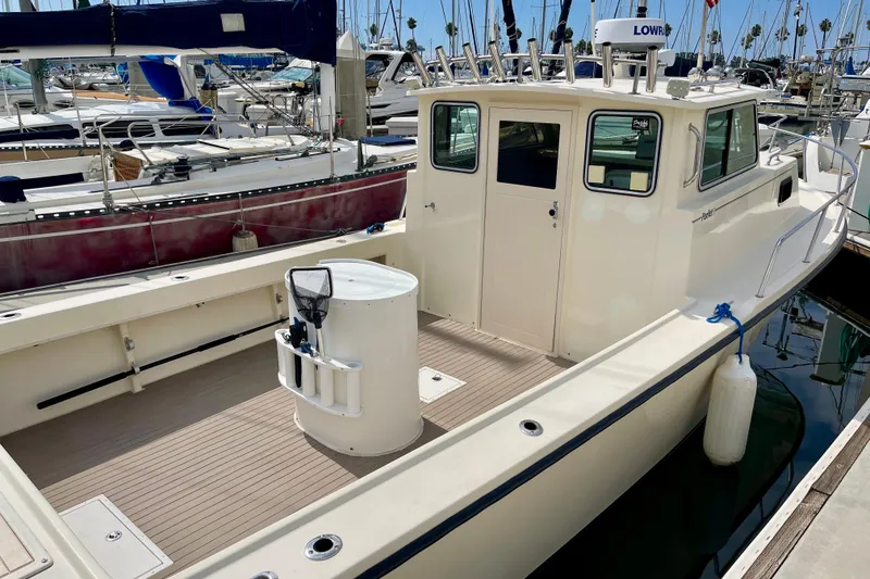 Slide: The Image of 2002 Parker 2520 XL Sport Cabin boat docked at marina, featuring spacious deck and cabin. - 5