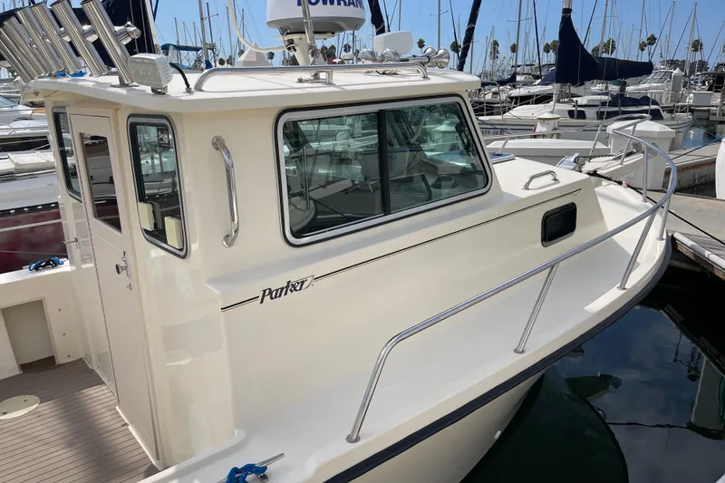 Slide: The Image of 2002 Parker 2520 XL Sport Cabin boat docked in marina, featuring sleek design and spacious cabin. - 6